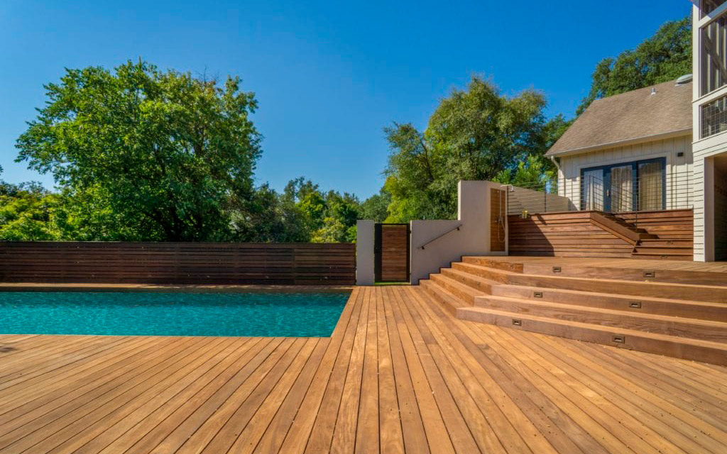 Tarima de exterior en madera IPE alrededor de una piscina en un patio de una casa particular proyecto de Ohc